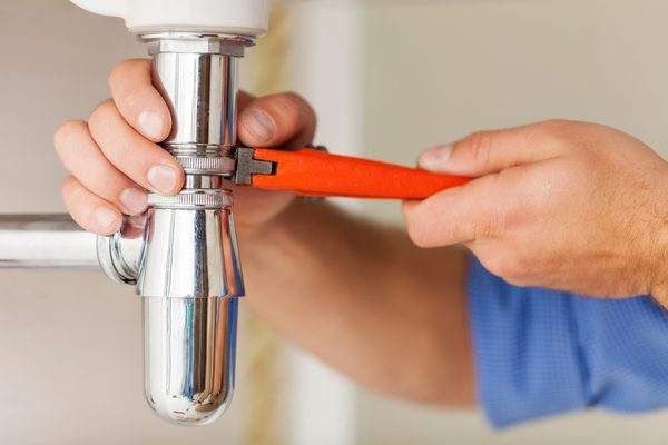 Plumber. Portrait of male plumber fixing a sink in bathroom